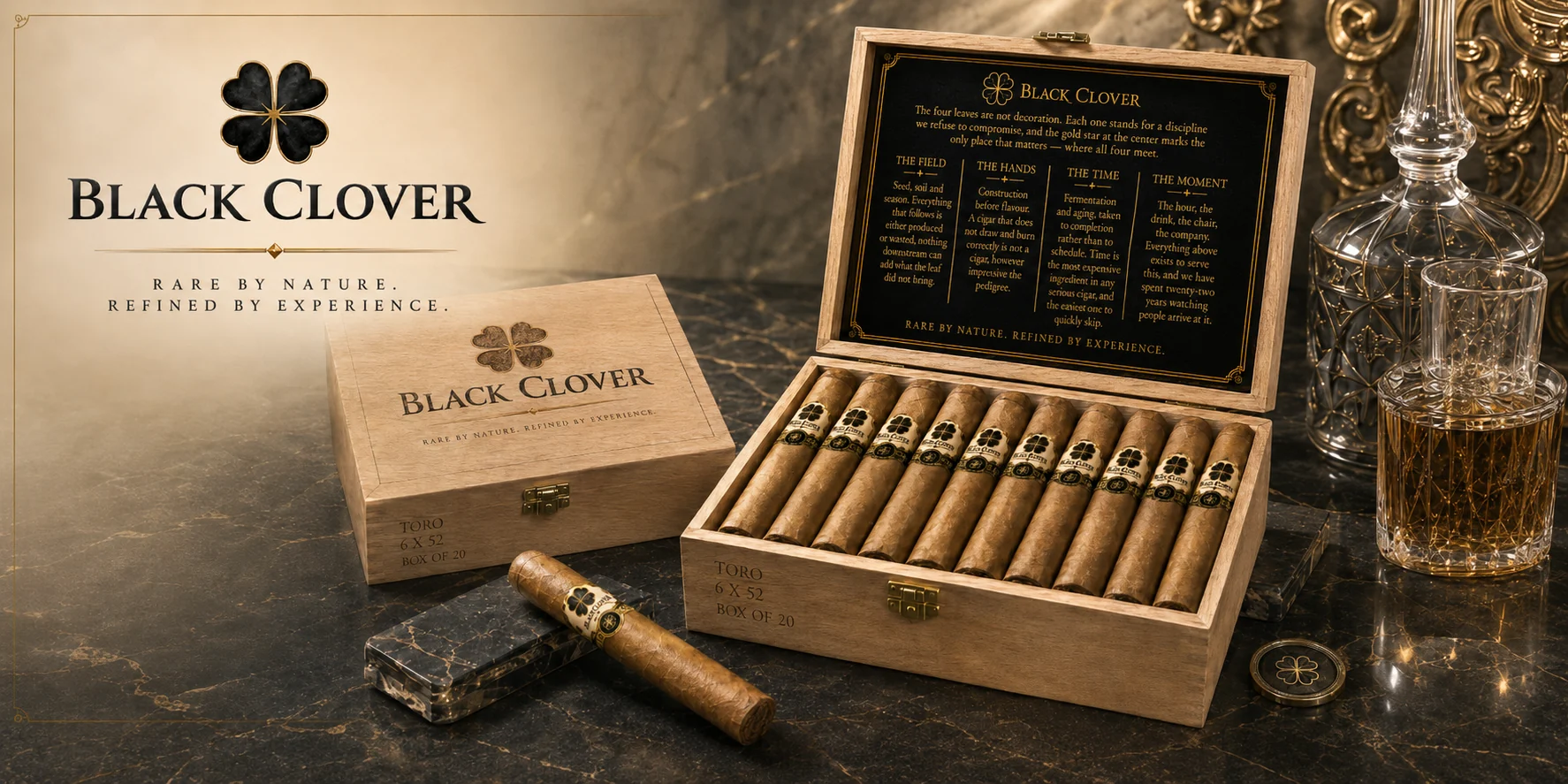 A Black Clover Toro cedar chest of twenty, open beside a closed box and a single cigar